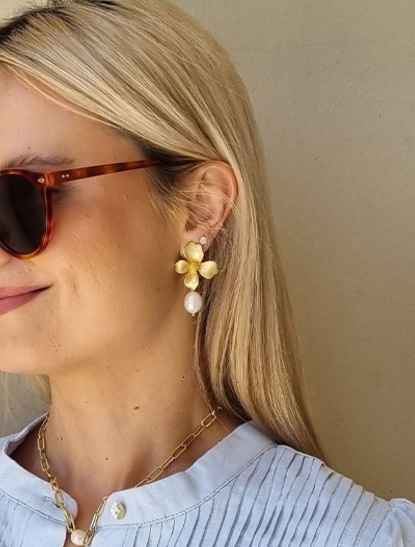 model wearing large gold flower earrings with pearl drop - zjoosh