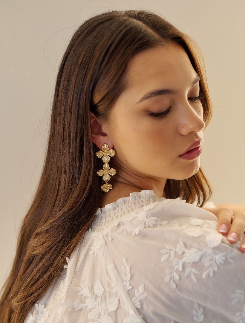 A girl wearing Zjoosh gold flower earrings