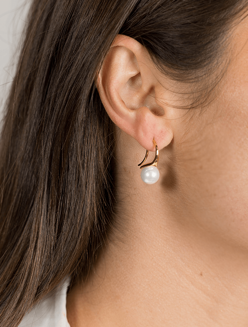 model wearing small gold hook earring with white pearl drop - zjoosh