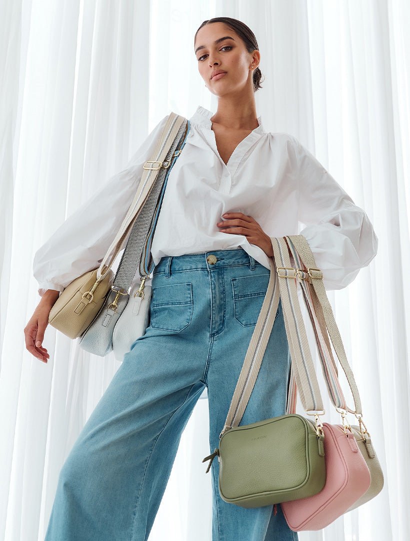 model holding a range of coloured crossbody bags from zjoosh