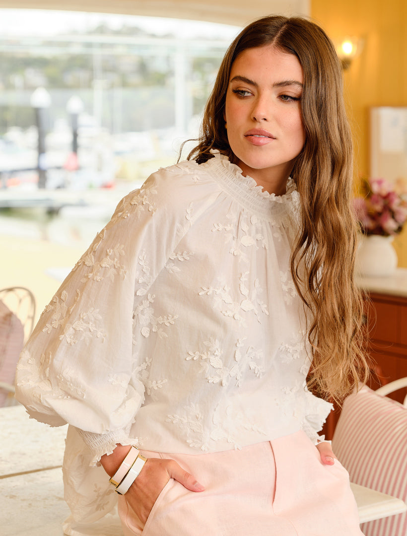 Zjoosh model wearing a white lace top with 2 bracelets