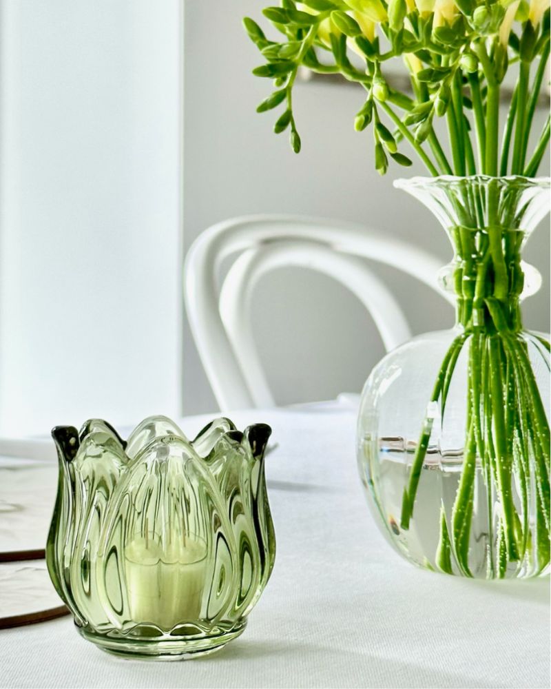 small green candle votive next to vase